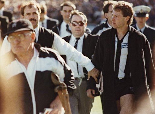 Leigh Matthews leads an injured Gavin Brown by the arm up the race at half time.
