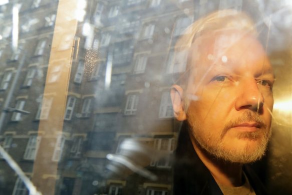 Julian Assange is taken from court in London in 2019.