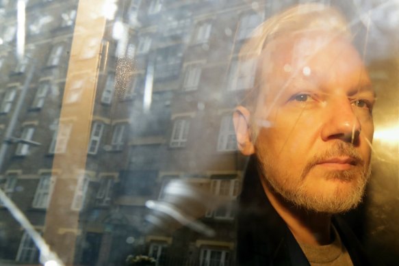 Julian Assange is taken from court in London in May.