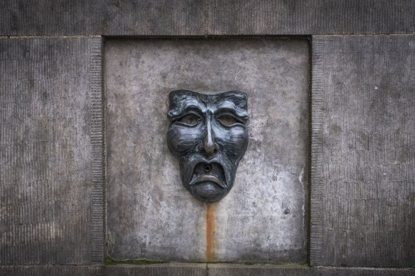 A bronze theatre mask on Edinburgh's Royal Mile in Scotland.