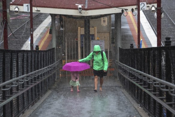 
Passengers make their way through the rain at Moorabbin station on Friday afternoon.