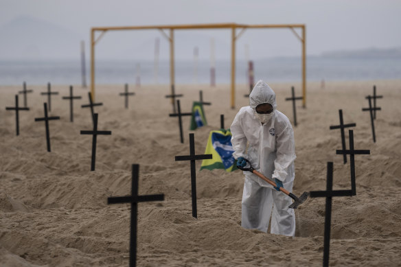 An activist digs symbolic graves on Copacabana Beach.