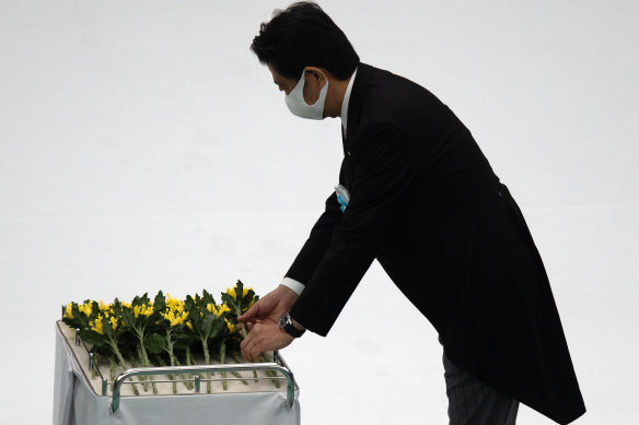 Japanese PM Shinzo Abe lays a flower during a memorial service marking the 75th anniversary of the end of World War II in Tokyo on Thursday.