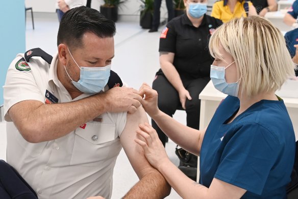 An emergency services worker getting a COVID-19 vaccination.
