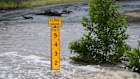 A flood gauge marks the height of water flowing over a farm-to-market road near Kerrville, Texas.