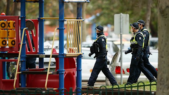 A police patrol walks past a playground in Melbourne.