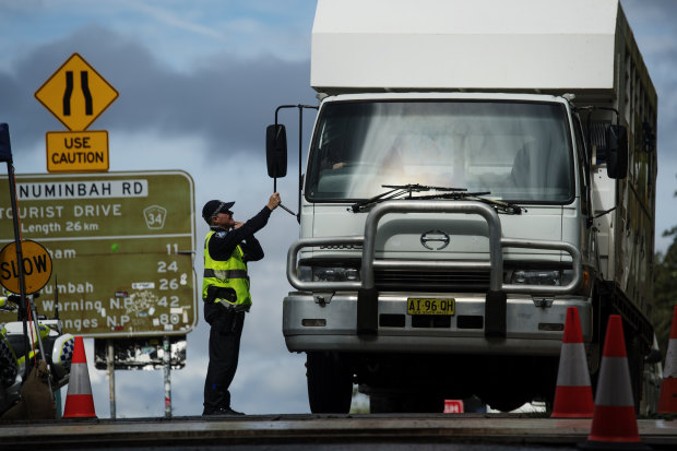 Police quizz a driver at a Queensland-NSW border checkpoint in the Gold Coast hinterland. 