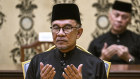 Malaysia’s newly appointed Prime Minister Anwar Ibrahim offers prayers after taking the oath during the swearing-in ceremony at the National Palace in Kuala Lumpur on Thursday. 