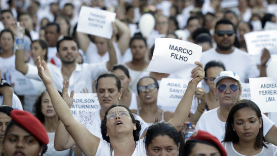 Friends and relatives hold signs with the names of victims of the Vale mining dam collapse, during a march in Brumadinho.
