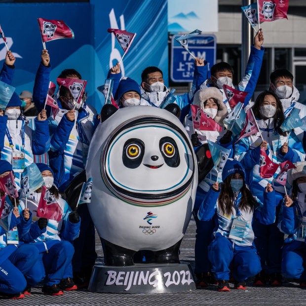 Olympic volunteers pose with the Games’ mascot Bing Dwen Dwen. 