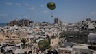 Palestinians rush to collect humanitarian aid airdropped by parachutes into Gaza City, northern Gaza Strip, Aug. 7, 2025.