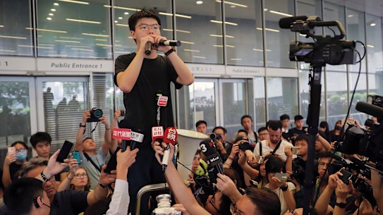 Pro-democracy activist Joshua Wong speaks to protesters near the Legislative Council in Hong Kong on Monday.
