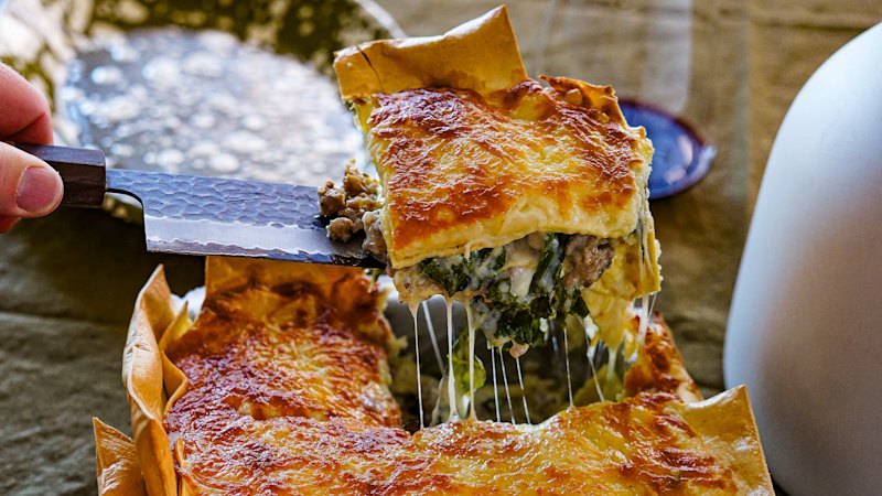 Three-cheese lasagne with pork sausage, kale and lemon