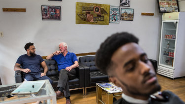 Des O'Brien chats to Mohammed Hassan while they wait at the barbers in the West Heidelberg Mall. 
