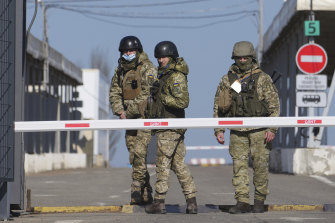 乌克兰边防警卫站在由俄罗斯支持的分离主义分子控制的领土检查站。