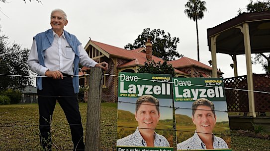 Former Nationals candidate George Souris stands outside his home with poster for current candidate David Layzell.