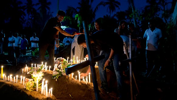 Relatives light candles after the burial of three victims of the same family, who died at Easter Sunday bomb blast at St. Sebastian Church in Negombo, Sri Lanka.