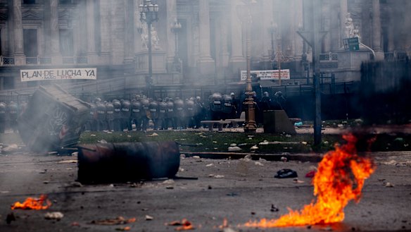 Police stand guard outside Congress as they clash with protesters as lawmakers discuss next year's budget in Buenos Aires, Argentina, last month.