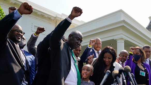 Lawyer Benjamin Crump, front centre, along with Gianna Floyd, daughter of George Floyd, and her mother Roxie Washington, and others talk with reporters after meeting with President Joe Biden at the White House.
