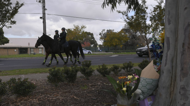 Police on horseback pass the crime scene on Wednesday afternoon.