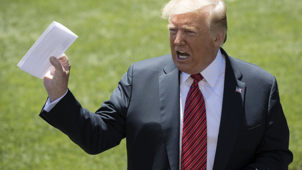 Donald Trump holds up the Mexican "deal" in front of the media on the White House lawn.