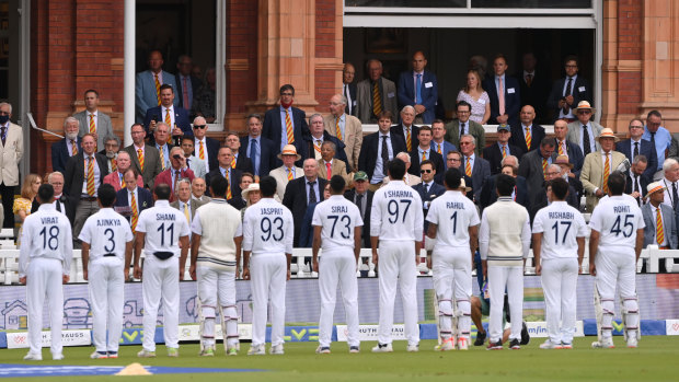 MCC members look on as the India team line up for the national anthem during day one.