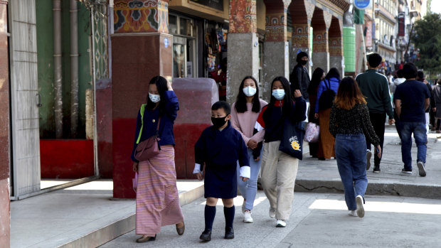Bhutanese people wear masks as a protection against coronavirus. The country has vaccinated almost 93 per cent of its adult population.