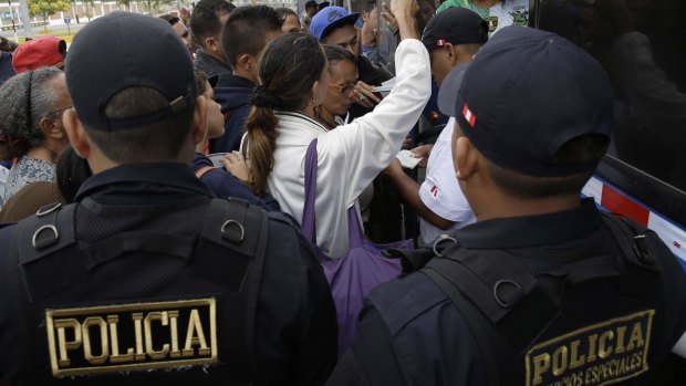 Venezuelan migrant try to get a ride in a bus to continue their travel in Peru on Saturday.