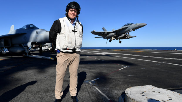 Australian Prime Minister Scott Morrison is seen on the flight deck as a EA-18G Growler lands on the USS Ronald Reagan, off the coast of Queensland.