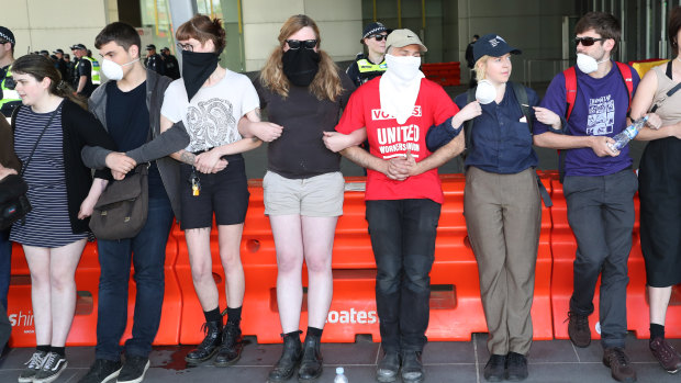 Protesters lock arms to try and stop people entering the convention centre. 