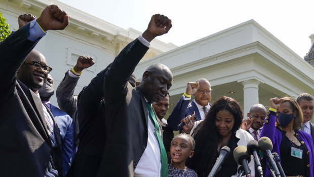 Lawyer Benjamin Crump, front centre, along with Gianna Floyd, daughter of George Floyd, and her mother Roxie Washington, and others talk with reporters after meeting with President Joe Biden at the White House.