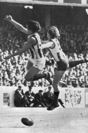Collingwood's Rene Kink and North's Daryl Sutton are eluded by the ball.
