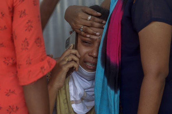 Relatives of a person who died of COVID-19 mourn outside a field hospital in Mumbai, India.