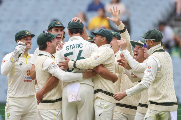 Mitchell Starc is embraced by his teammates after dismissing Sarel Erwee.