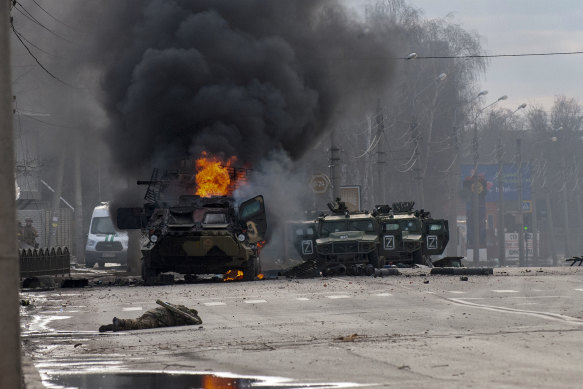An armoured personnel carrier and light utility vehicles stand abandoned after fighting in Kharkiv.