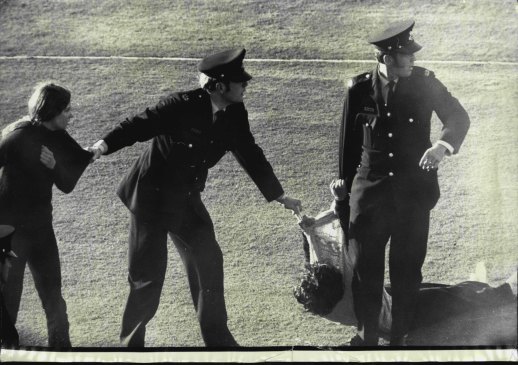 Verity Burgmann standing and Meredith Burgmann on the ground being dragged from the pitch at Springbok demonstrations at the SCG on July 6, 1971.