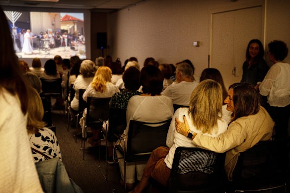 Women in Caulfield North watch a livestream of a memorial event in Bondi on Sunday. 

