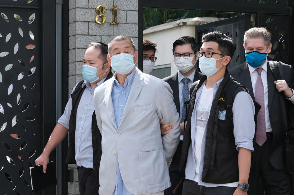 Jimmy Lai, chairman of Next Digital is led away from his residence by law enforcement officials in Hong Kong on Monday.