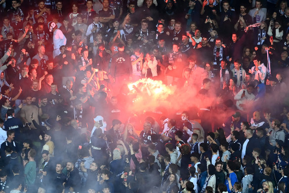 Flares are let off in the crowd during the round three Melbourne derby. 