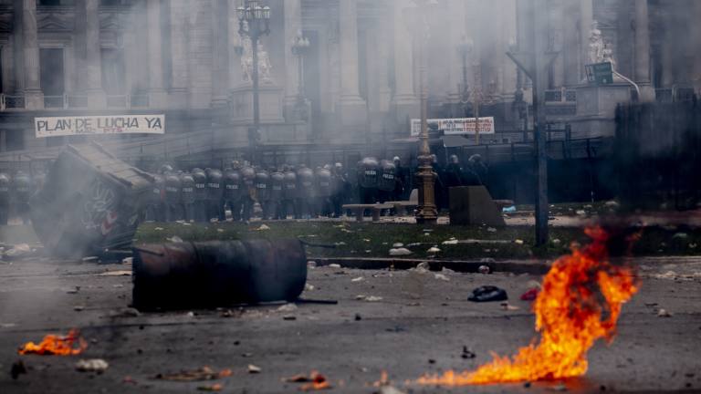 Police stand guard outside Congress as they clash with protesters as lawmakers discuss next year's budget in Buenos Aires, Argentina, last month.