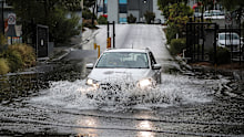 THE AGE NEWS February 24, 2026. A car drives through floodwater on Lloyd Street in Kensington caused by heavy rain. A weather warning is in place for much of Victoria after Melbourne was hit by a wild storm this afternoon. Photo by Paul Rovere