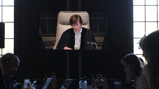 Address o at the opening session of Presiding judge Joan Donoghue is broadcasted in the media room at the International Court of Justice, or World Court, in The Hague, Netherlands, Friday, Jan. 26, 2024. Israel is set to hear whether the United Nations’ top court will order it to end its military offensive in Gaza during a case filed by South Africa accusing Israel of genocide. (AP Photo/Patrick Post)