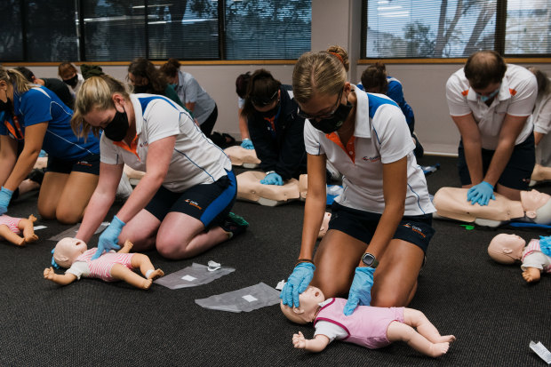 Students practise CPR for children (front) and adults (back) on “Annie” dummies during a class at Carlile Swimming in Lane Cove West. 