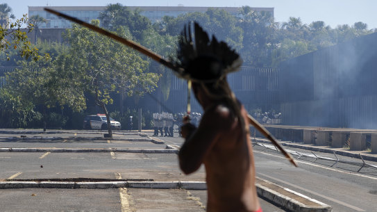 An Indigenous protester aims his bow an arrow at police outside Congress in Brasilia, Brazil.