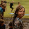 Lara Bowden, 10, playing in the mud in the wake of ex-cyclone Alfred, at Skennars Head in northern NSW