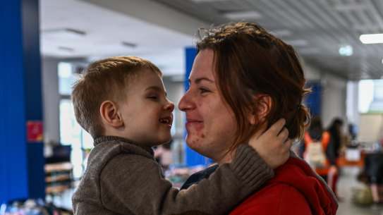 A woman who fled the war in Ukraine comforts a child at a temporary shelter in Krakow, Poland.
