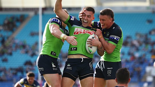 Nick Cotric celebrates a try with Raiders teammates.