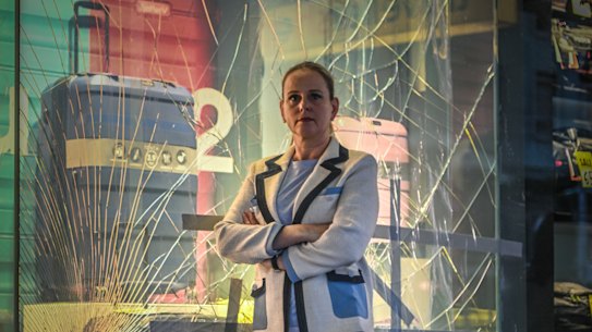 Anja Faustein in front of a smashed window.