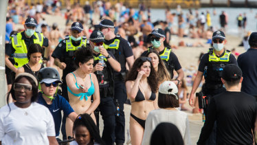 Crowds and police on St Kilda Beach.