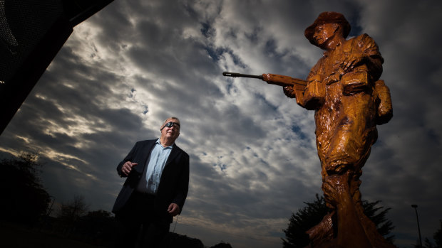 Bill Cantwell with the sculpture in Greensborough War Memorial Park of himself as a Vietnam War soldier.